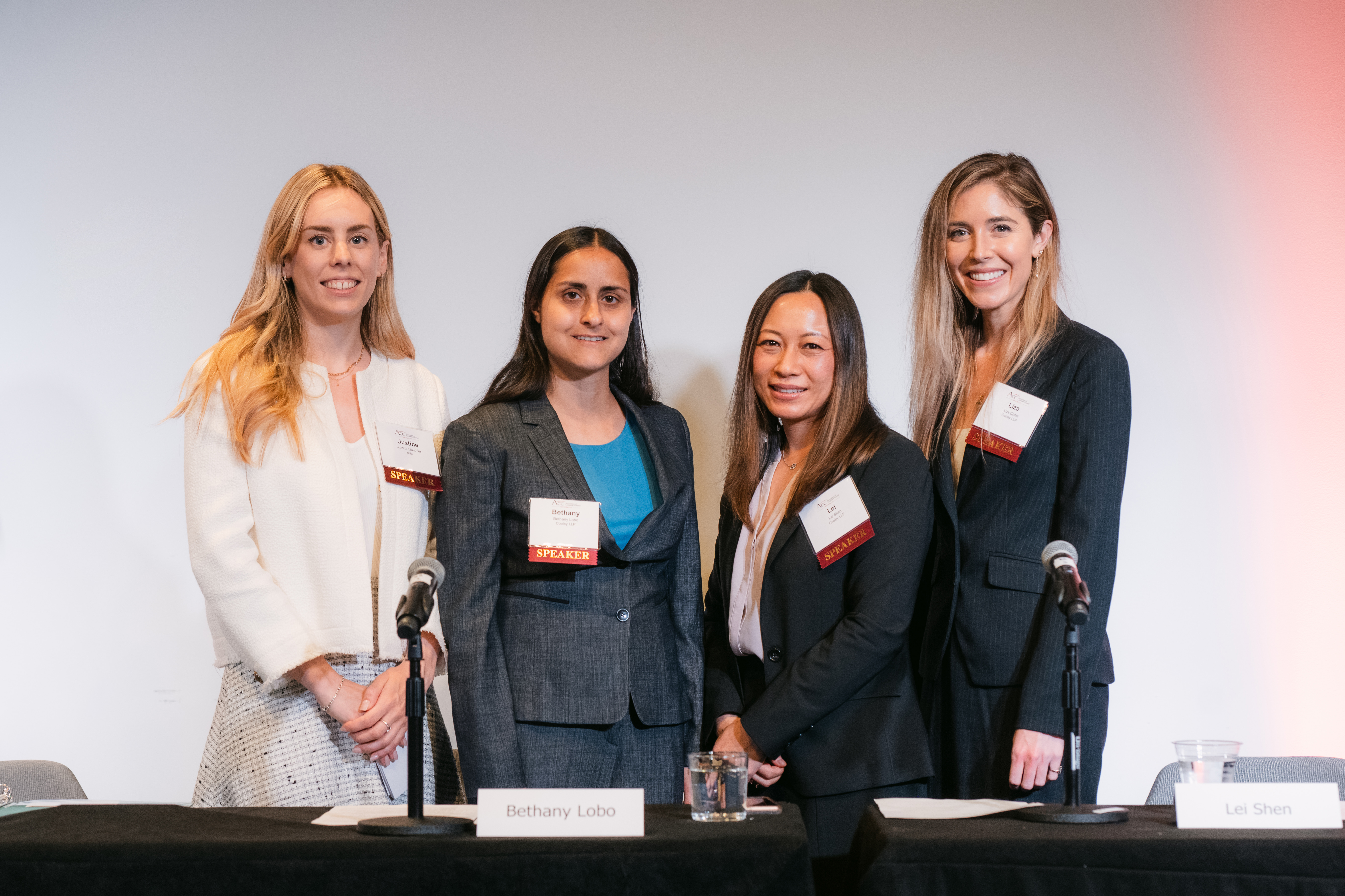 Four prominent women panelists standing close together for a photo.