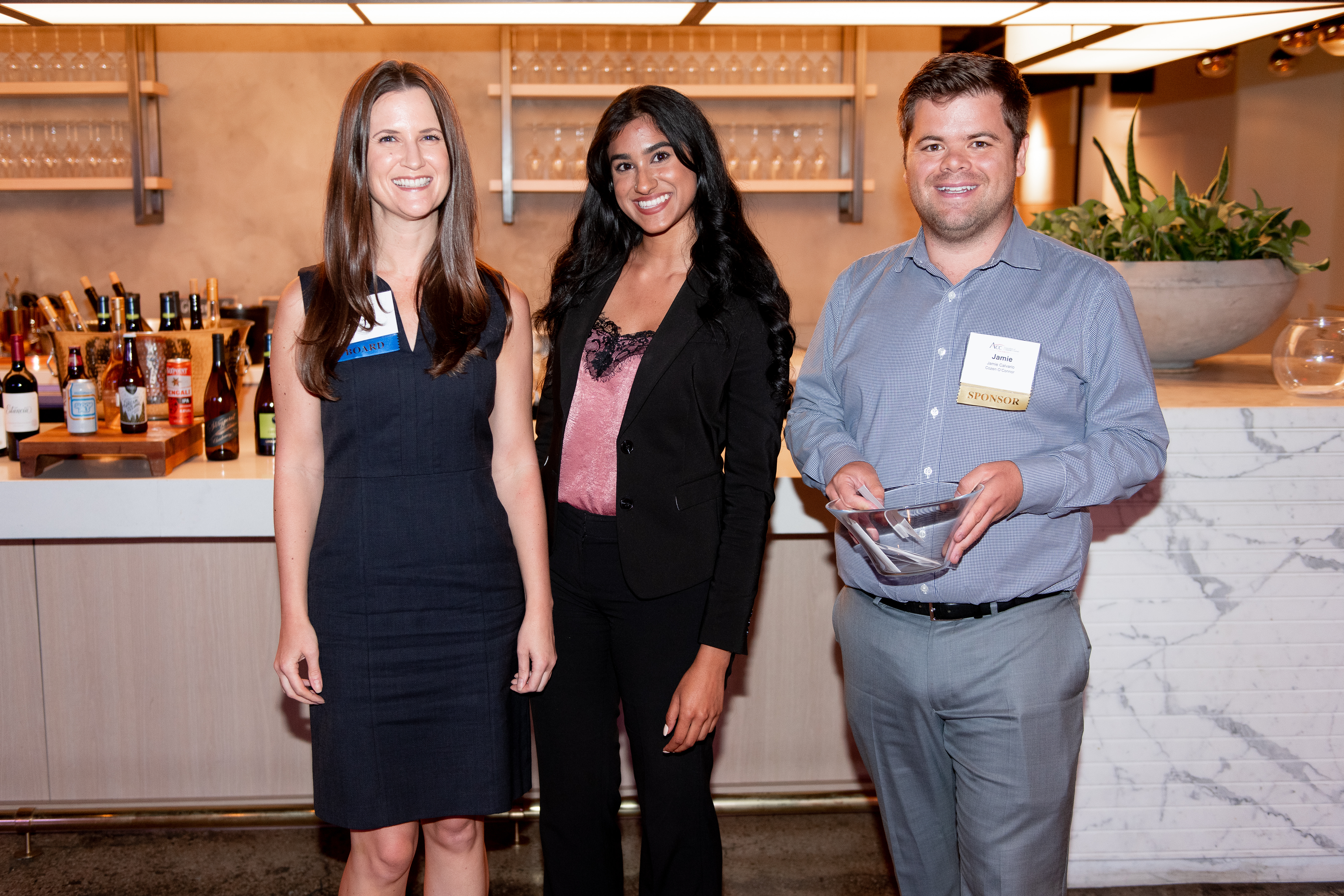 Two ladies and a gentleman grinning wide for a photo.