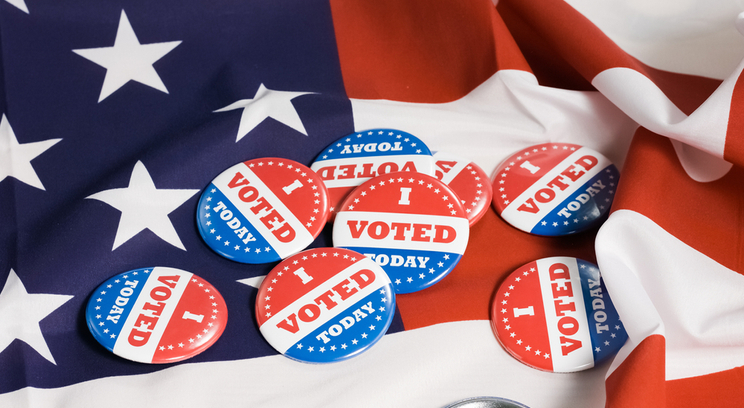 several i voted today buttons on an American flag