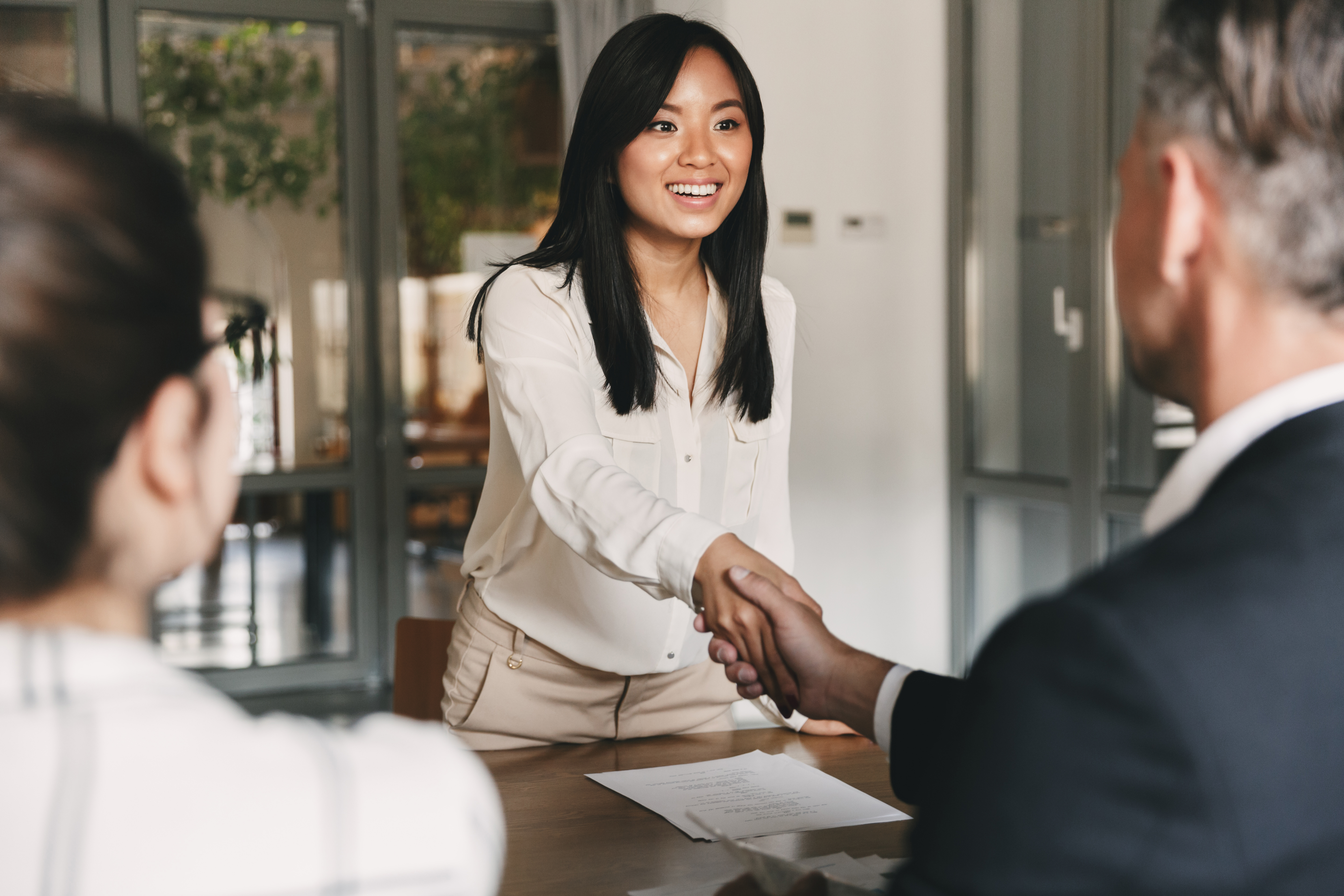 Woman shaking hands with interviewer.