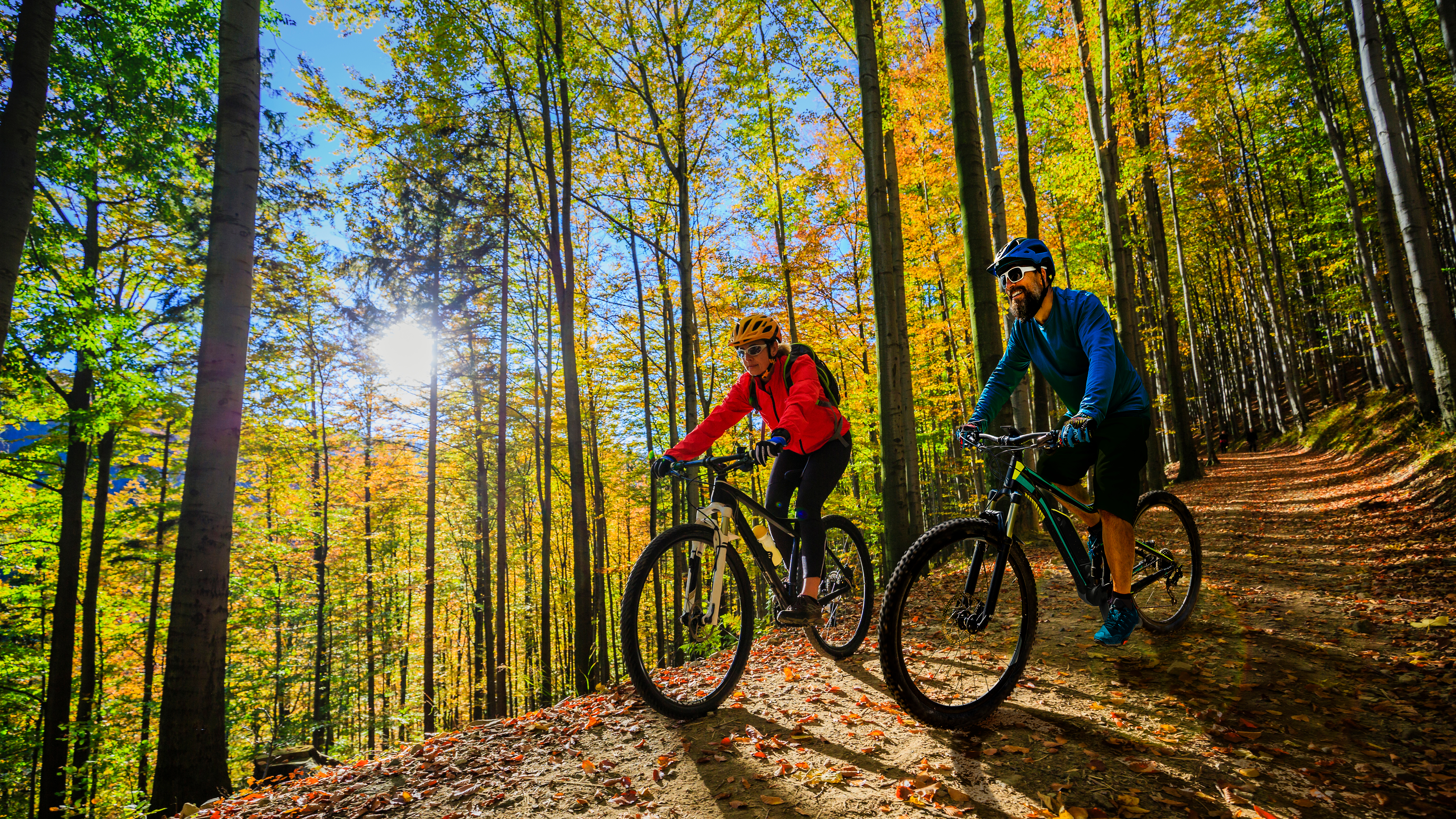 A woman and man biking in nature.