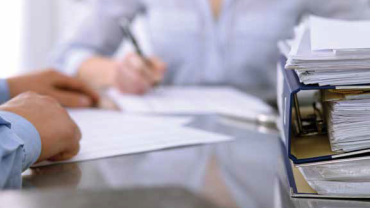 two people at a table with paper between them