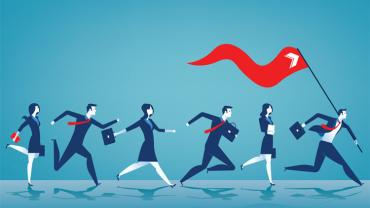 Several businesspeople following a leader with a large red flag