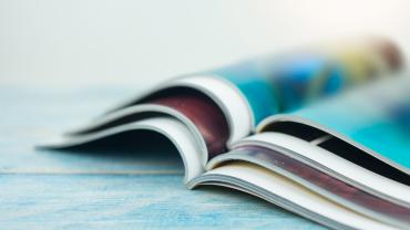 Magazines stacked on a table.