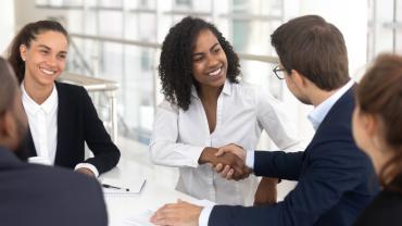 Group of multiracial business people shaking hands in a board room.