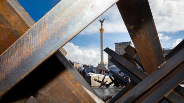 buildings with mass of wood beams crossed over and in front, indicating destruction