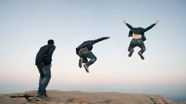 looks like man about to jump outside, horizon in back, jumps, jumps higher with arms up