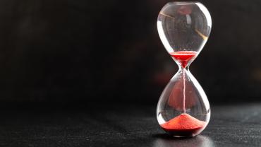 hourglass with sand running through and much already on bottom