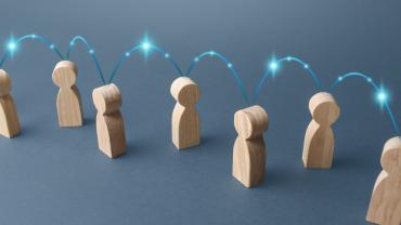 wooden figures == illustration or photo -- with lights jumping from figure to figure and start above each as though sharing information and helping