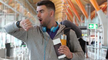 man, white, it appears, in airport looking at watch, panicked