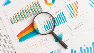 Magnifying glass over a stack of papers. 