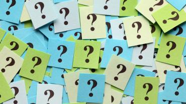 Blue and green sticky notes with question marks. 