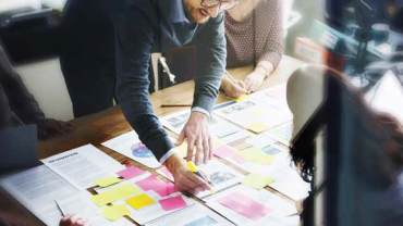 business people marking documents with highlighters and sticky notes