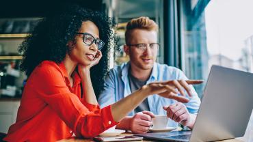 two business people discussing something on a laptop