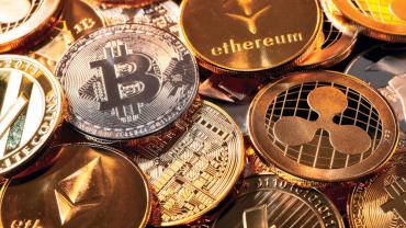 a pile of coins with the names of virtual currencies