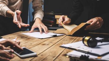 several documents being discussed around a table