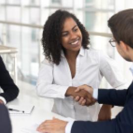 Group of multiracial business people shaking hands in a board room.