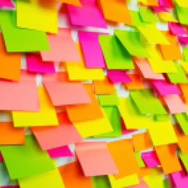 Dozens of bright, colorful sticky notes covering a whiteboard.