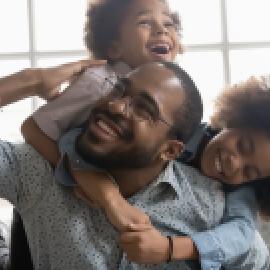 Two children hugging their father