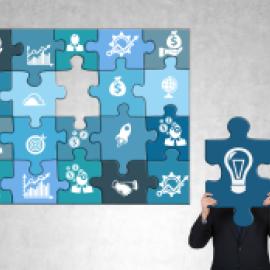 puzzle with different illustrations on each such as money bags, bar chart showing increases, hands shaking, with one missing piece, next to it person in suit, head covered by the missing piece with a lightbulb symbolizing idea