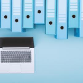 Computer under a long row of binders. 