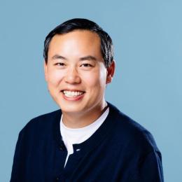 Headshot of Stephen Mar against a blue background. 