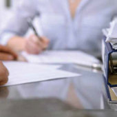 two people at a table with paper between them