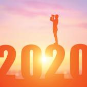 Figure standing on top of 2020 and looking back with binoculars