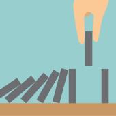 a hand preventing a line of dominoes from collapsing