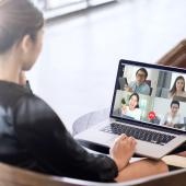 Businesswoman sitting in front of a laptop for a virtual meeting.