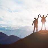 three business people on top of a mountain