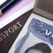 a pencil, passport, and visa are laid out on a table