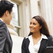 two professionals speaking out side a government building