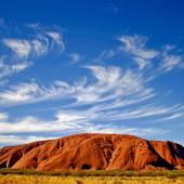 uluru rock with blue sky and wispy clouds