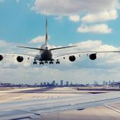 a plane about to land with the city in the distance