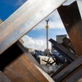 buildings with mass of wood beams crossed over and in front, indicating destruction