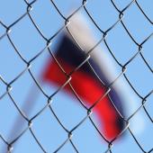 Russia flag behind chain link fence