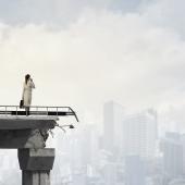 business woman standing on a destroyed bridge