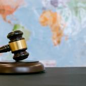 judge's gavel in front of map of the world