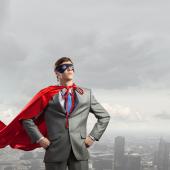 man (appears to be, white), in suit, wearing red cape like Superman type, eye mask, cape floating like he might have flown or will fly, skyline in background like he's above it