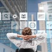 person, appears white, in chair, leaning back looking at window with icons representing, perhaps, types of work