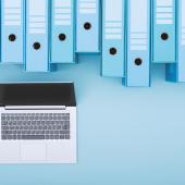 Computer under a long row of binders. 