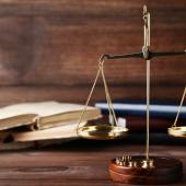 Scales on a table next to legal books. 