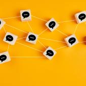 Wooden blocks with chat boxes drawn on them interconnected with strings. 