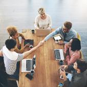 Workers shake hands across a table