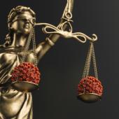 a statue of blind lady justice with covid-19 virus cells balanced on the scales